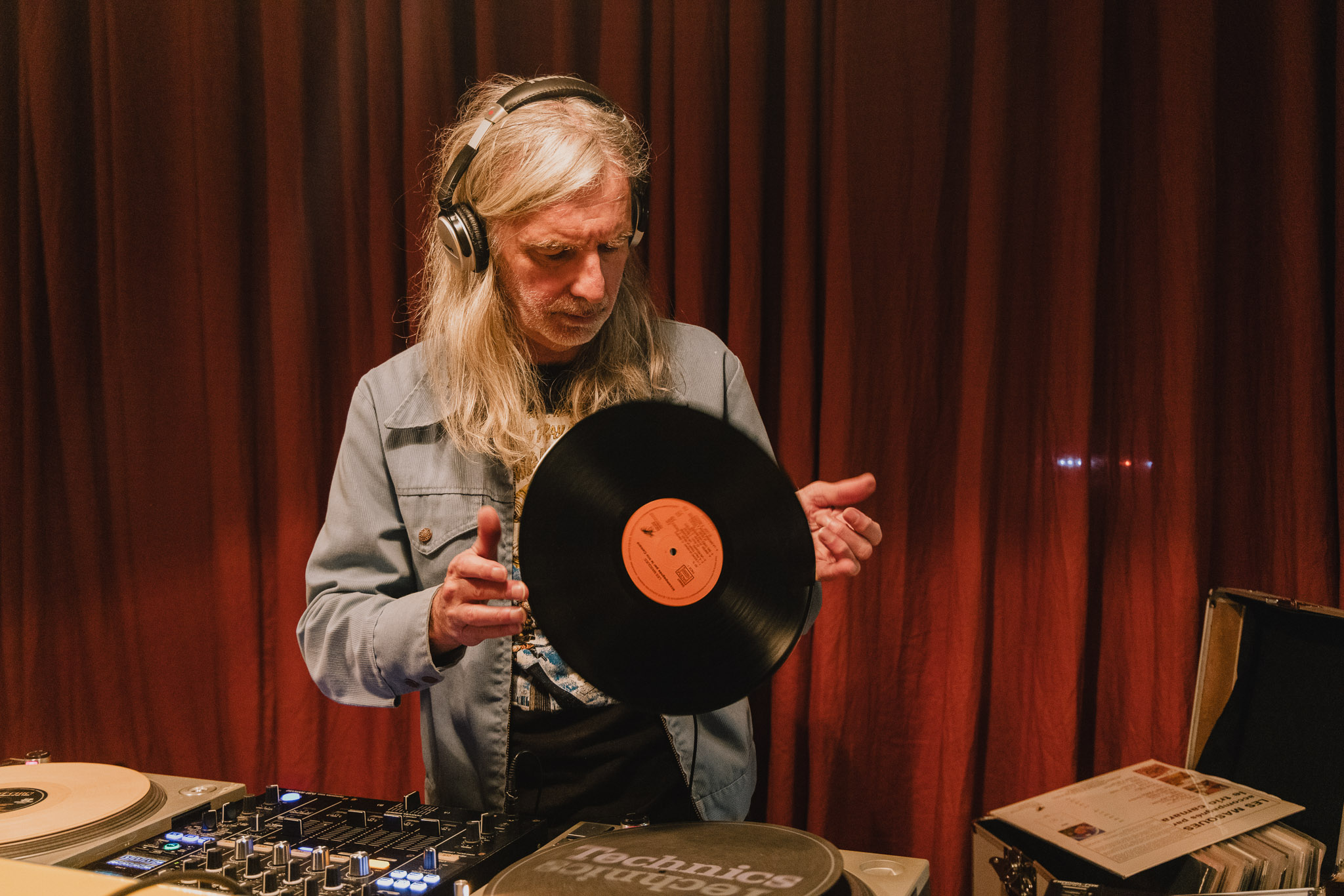image of a person with long white hair holding a vinyl record while djing